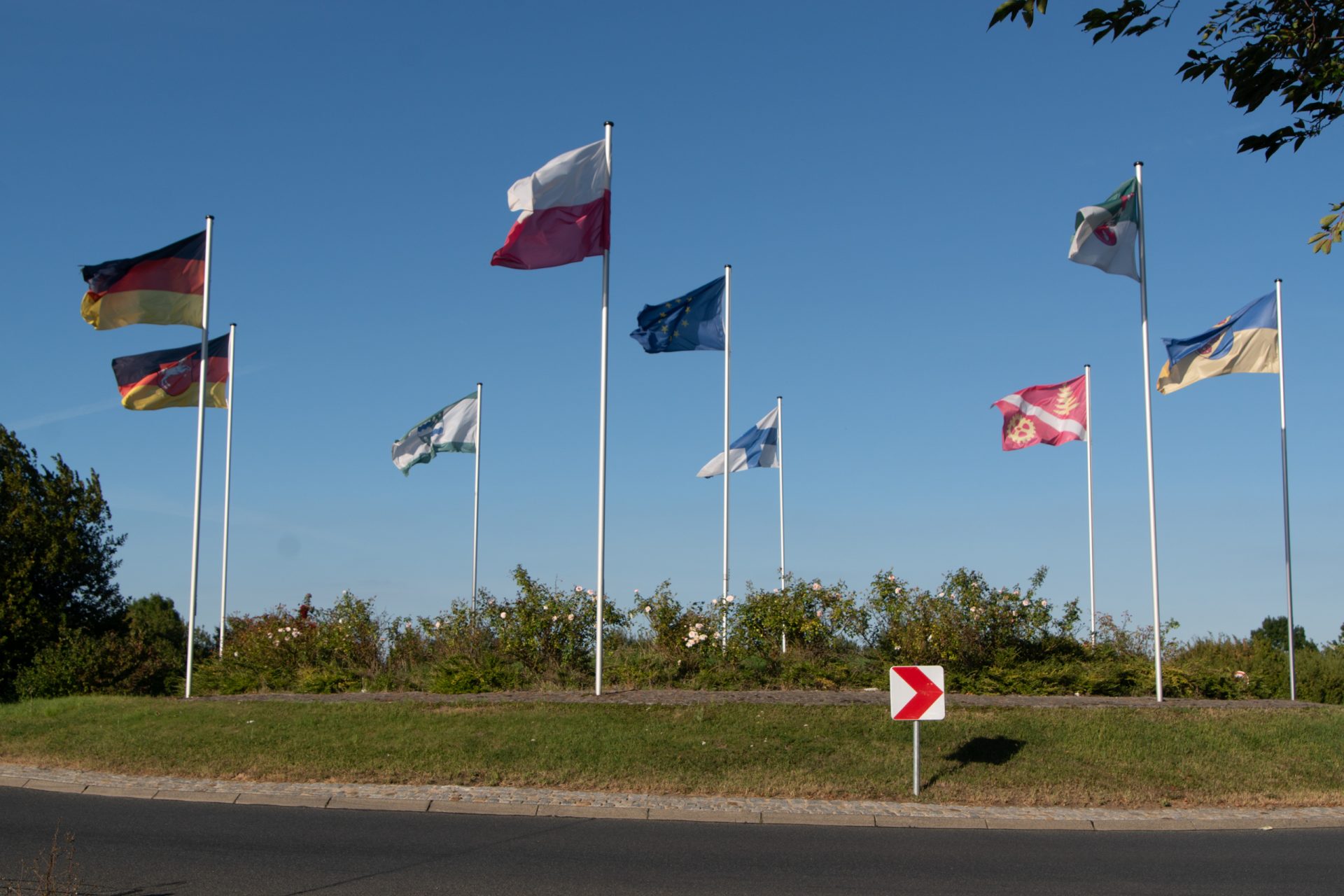 Mehrere Fahnen verschiedener Nationen und Organisationen, die am Europakreisverkerh in Vechelde wehen.